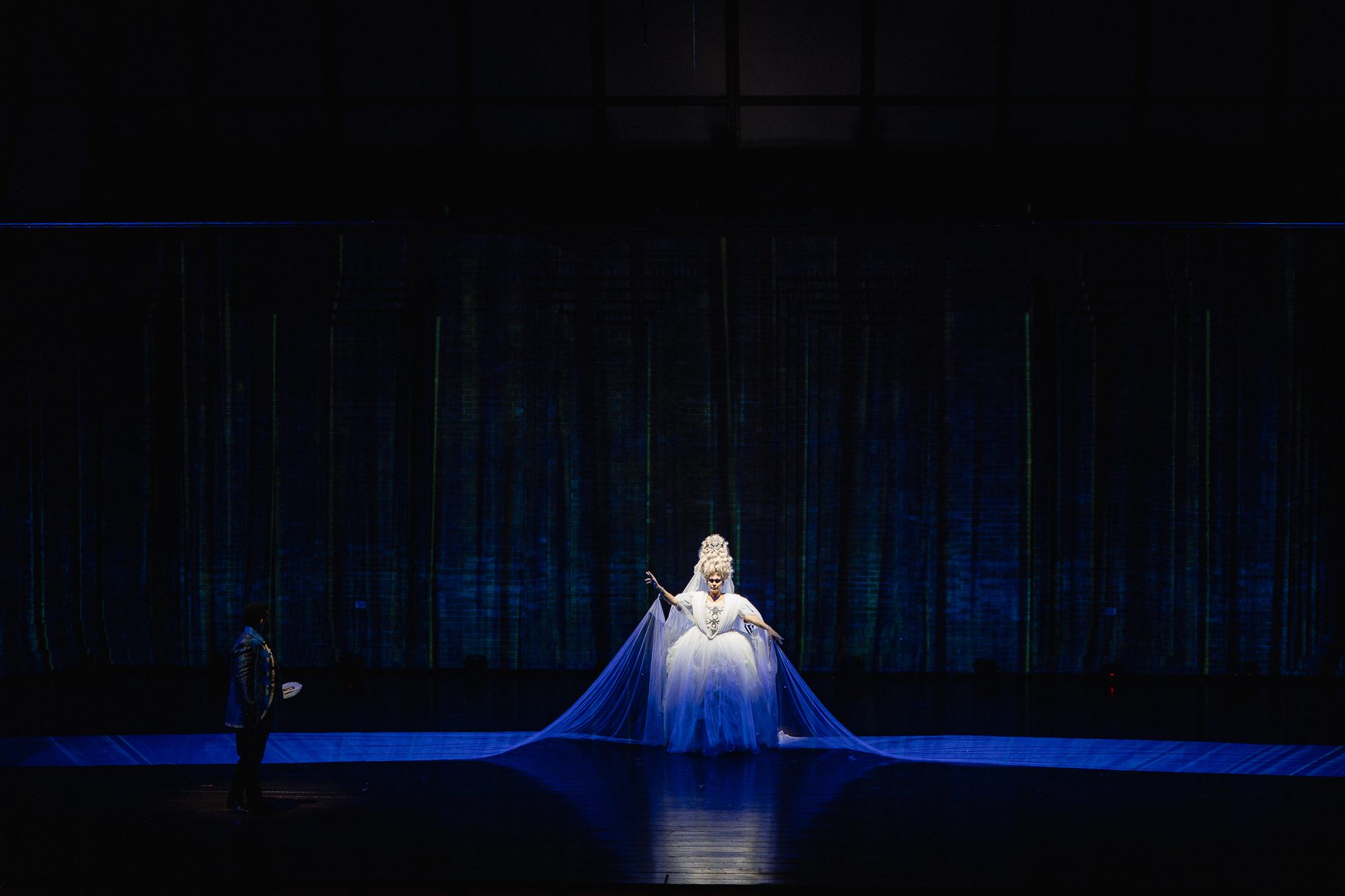 A Rainha da Noite sozinha em cena, com o manto azul estendido pelo palco
